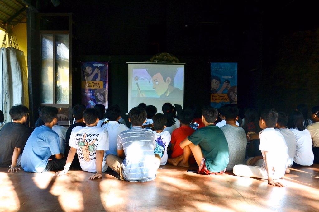 Children watching a Stairway animated film in an auditorium